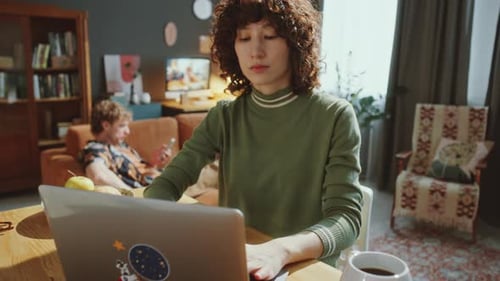 Woman Works on Laptop at Home on Desk