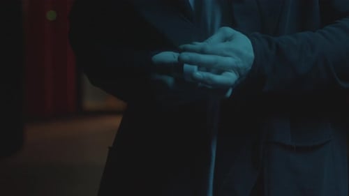 Hands Fidgeting with Small Round White Object