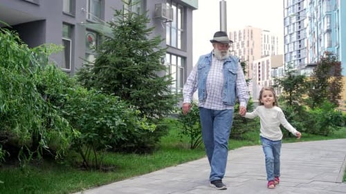 Grandfather and Granddaughter Walking Together in the City