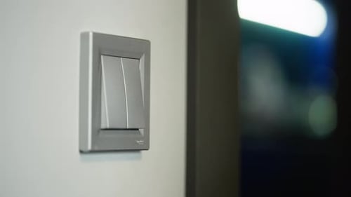 Hand Turns on Modern Light Switch