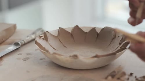 Hands Shaping Clay Bowl with Pottery Tools
