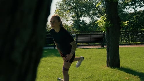 Woman Doing Resistance Band Leg Lifts in Park