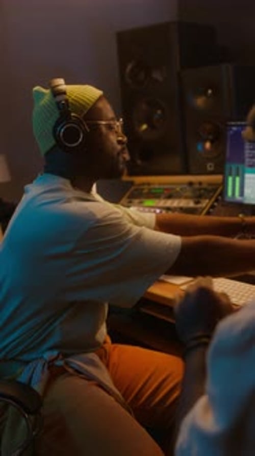 Black Male Producer and Sound Engineer Editing New Rap Song in Studio