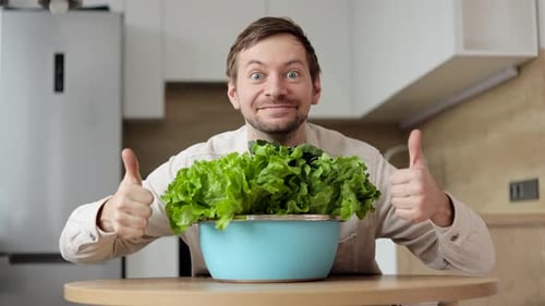 Excited Man With Fresh Lettuce Thumbs Up in Kitchen