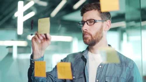 creative young entrepreneur business man in modern office uses post Papers sticky notes to share