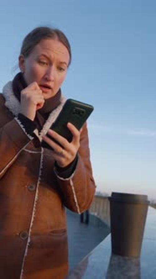 Woman Celebrates Good News on Phone Outdoors