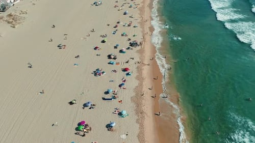 Enjoying a Sunny Beach Day Filled with Colorful Umbrellas and Gentle Waves Crashing