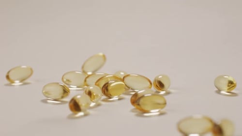 Gel Capsules Falling on White Surface