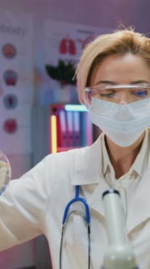 Scientist Inspects Liquid in Flask in Lab