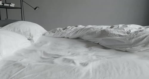 Empty Bed with White Sheets and Pillows