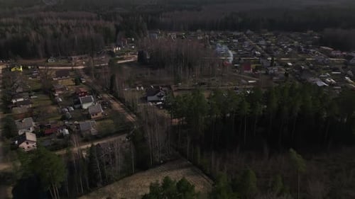 Aerial View of Rural Town Surrounded By Lush Forest with Buildings and Trees