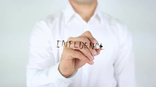 Man Writes the Word Influence on Glass