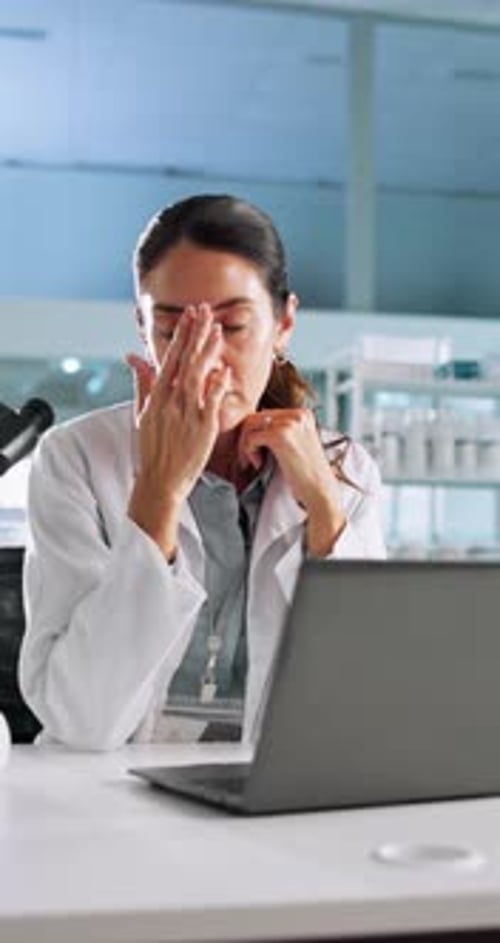 Stressed Professional Woman Rubbing Temples at Desk