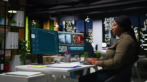 Woman Editing Video Footage at Night in Office