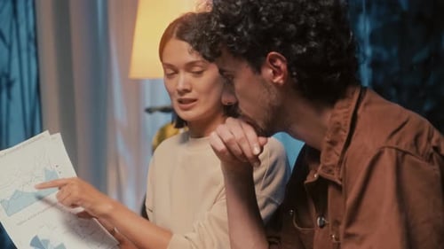Woman and Man Sharing Ideas about Diagram on Paper at Home Office