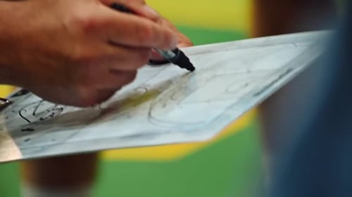 Coach Drawing Play on Whiteboard in Gym