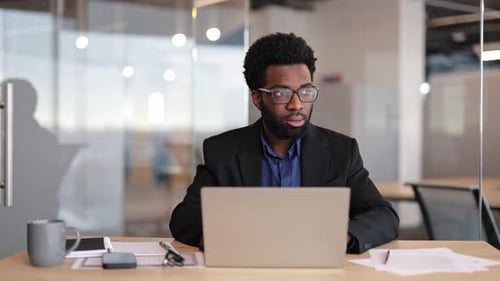 Businessman Working on Laptop in Modern Office Focused Professional Analyzing Data