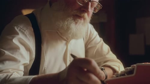 Älterer Schriftsteller, der tief in Gedanken versunken ist und am Schreibtisch einen Buchentwurf schreibt
