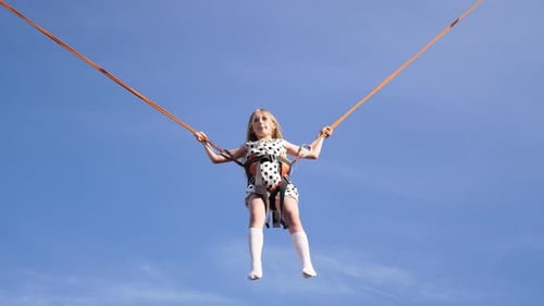 Little Happy Girl Jumping on a Trampoline