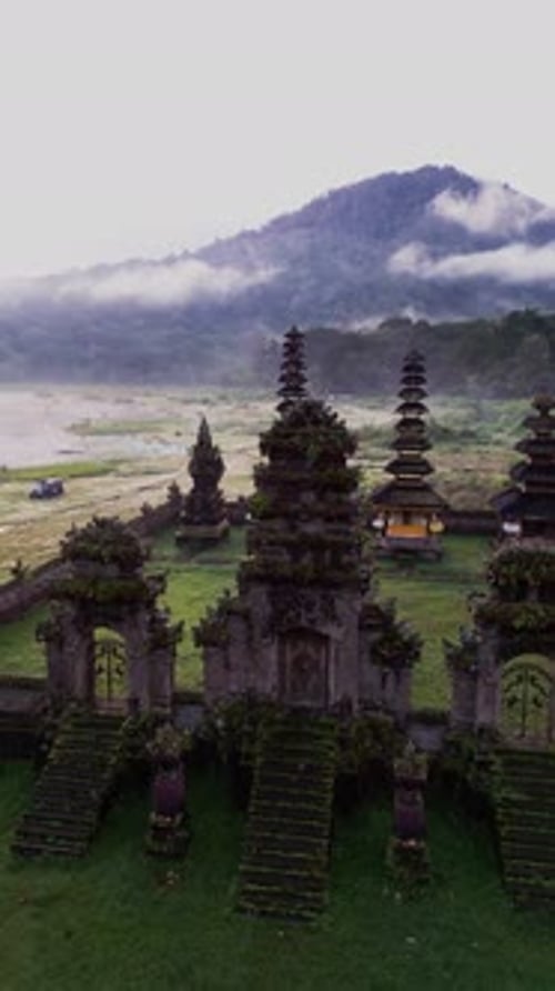 Temple Misty Highland à Bali vu d'en haut avec un lac paisible et une montagne encadrés au loin