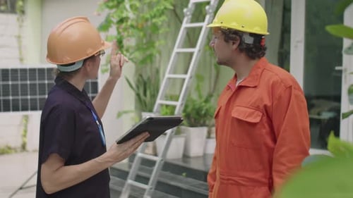 Female Engineer Instructing Worker about Solar Panels Installation