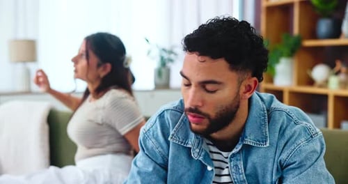 Couple, man and frustrated on sofa after fight, disagreement and toxic relationship in lounge