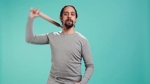 Young Adult Poses with Rolling Pin in Studio
