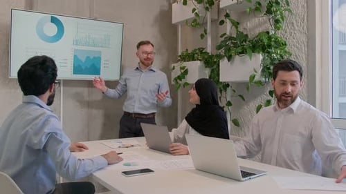 Team Leader Explain Business Project to Colleagues in Office Boardroom Show Presentation Graphs