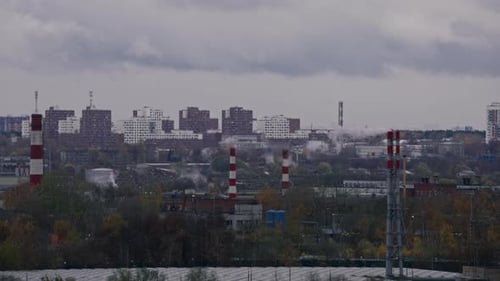Kraftwerksschornsteine, die Emissionen über dem Stadtviertel freisetzen