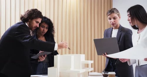 Architect shares detailed building plans with colleagues in a design meeting