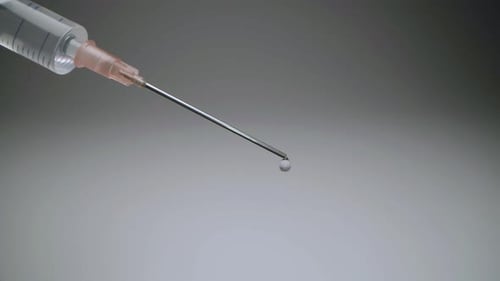 Close-up of a vaccine syringe dripping clear liquid with copy space. Concept of immunizations for th