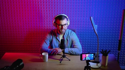 Young Adult Podcasting Into a Microphone in Studio