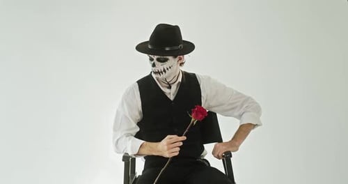 Man in Day of the Dead Makeup Sitting in Chair