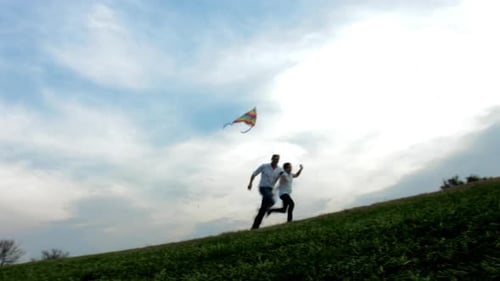 Father and Daughter Flying Kite on Open Field at Sunset, Steadicam