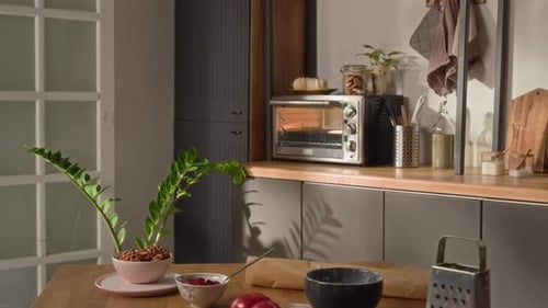 Elektroherd auf Küchenarbeitsplatte und Holztisch mit Pizzazutaten