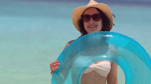 Woman With Swim Ring on a Tropical Beach
