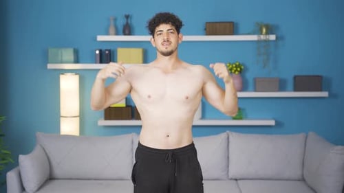 Fit Man Poses and Flexes Biceps Indoors