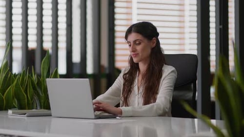 Businesswoman Working on Laptop in Modern Office