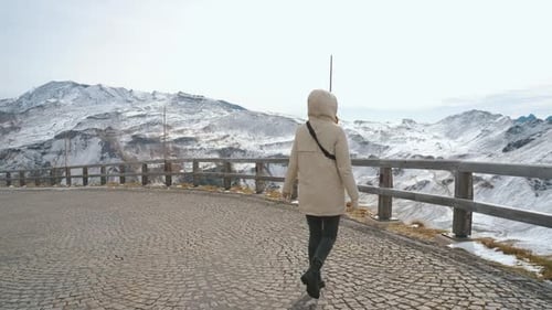 Beautiful Girl Traveler Walks Along Majestic Grossglockner Mountain Road in Austria Snow Covered