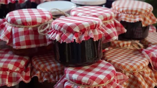 Les pots de conserves faites maison avec couverture vichy sont un ajout charmant à une cuisine de campagne