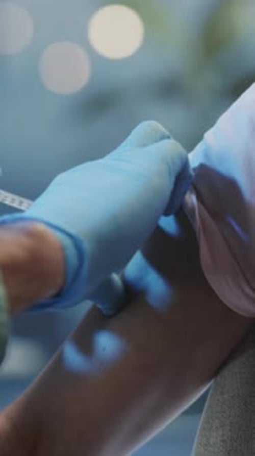 Arm Receives Injection From Medical Professional Close Up
