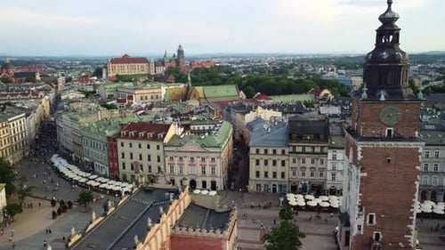 Town hall tower in main square of Krakow Old Town with busy street and apartments