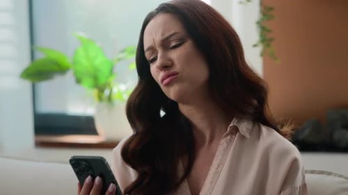 Woman Frustrated Using Cellphone at Home