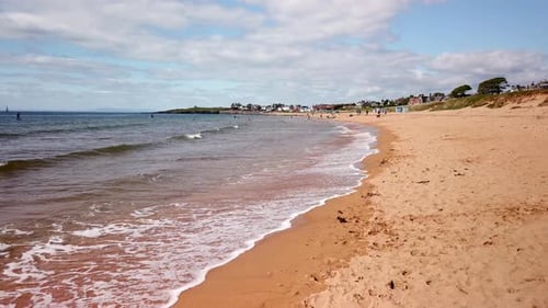 Golden sands and gentle waves looking towards Earlsferry on the east coast of Fife Scotland with bea