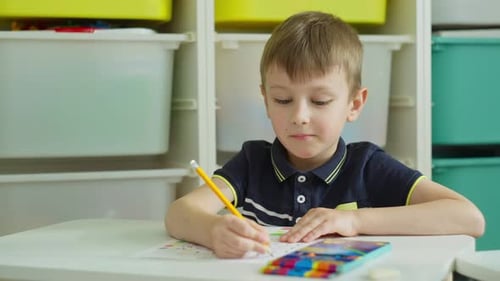 Der Junge konzentriert sich mit einem Bleistift auf eine einzelne Aufgabe