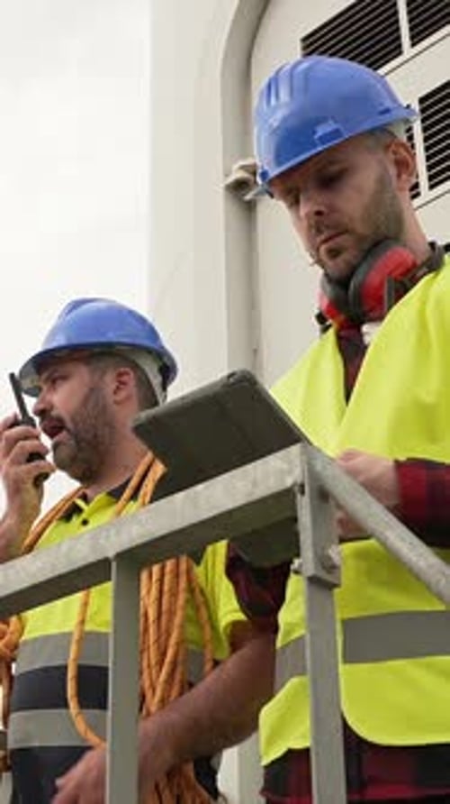 Elektrotechniker, die mit Tablet und Walkie-Talkie im Windkraftwerk arbeiten