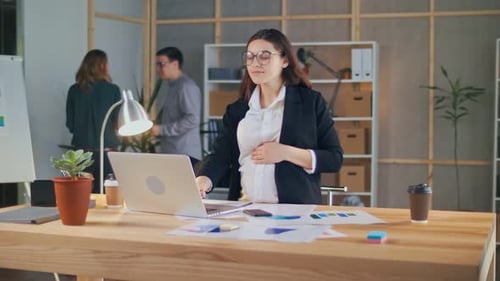 Une femme d'affaires enceinte prospère travaille avec des collègues