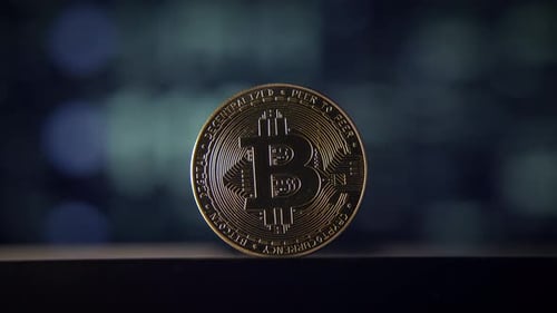 A Shiny Bitcoin Coin Stands Out Against a Dark Bokeh Background Creating a Striking Visual