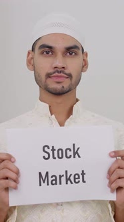 Vertical Video of Muslim Man Holding Stock Market Poster