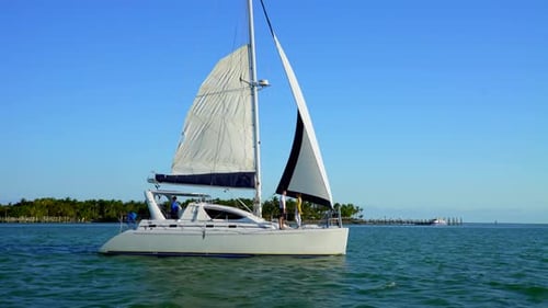 Couple sailing a catamaran in turquoise bahamas waters near paradise island